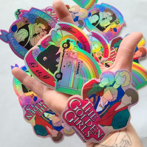 four queer stickers: rick and evy, Gillian anderson, rainbow uhaul and golden girls