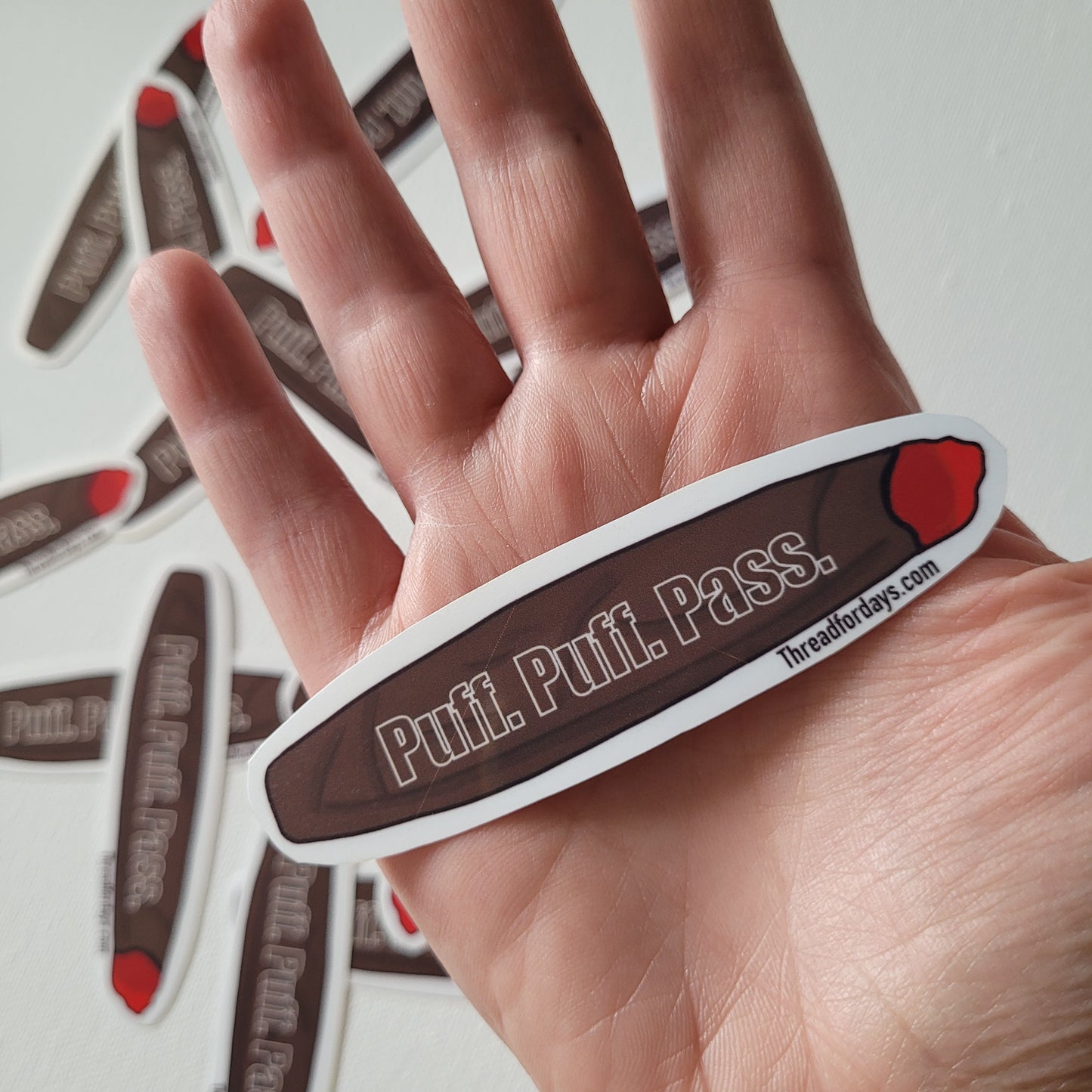 puff puff pass sticker helf in palm to indicate size