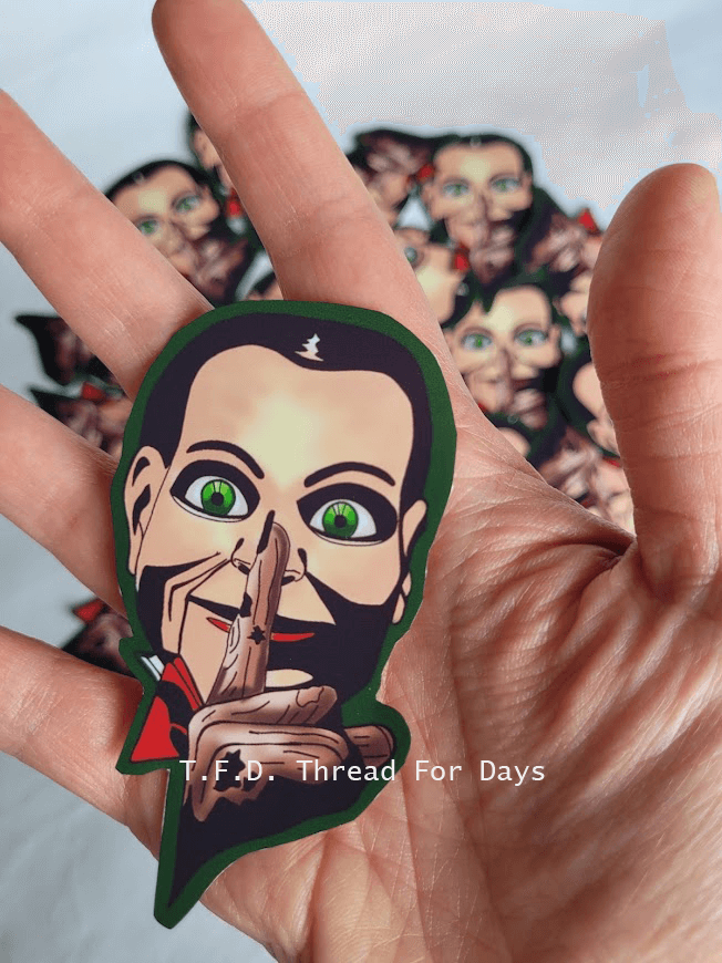 Billy the doll vinyl sticker held in palm of hand