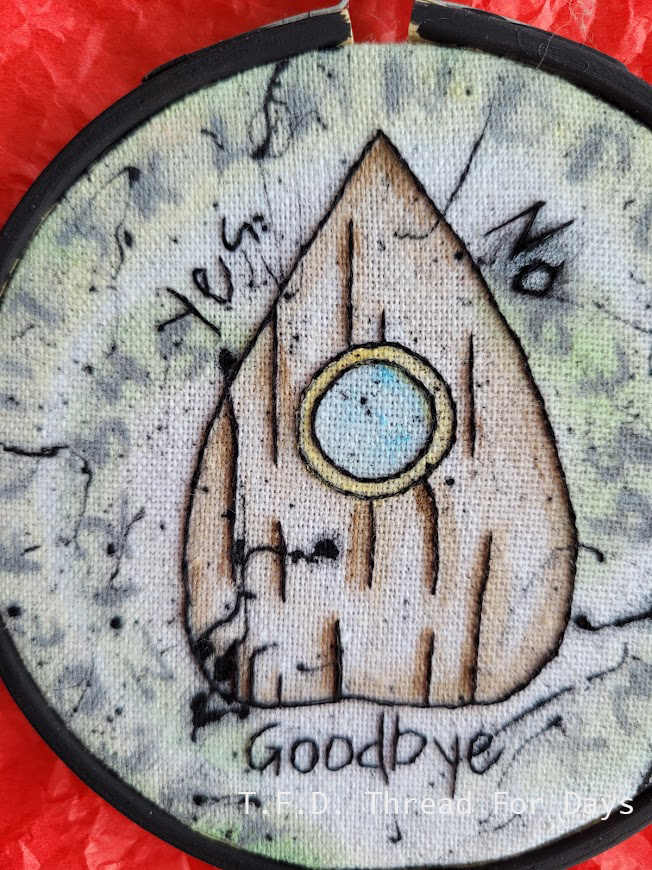 close up of stitches on ouija planchette embroidery hoop