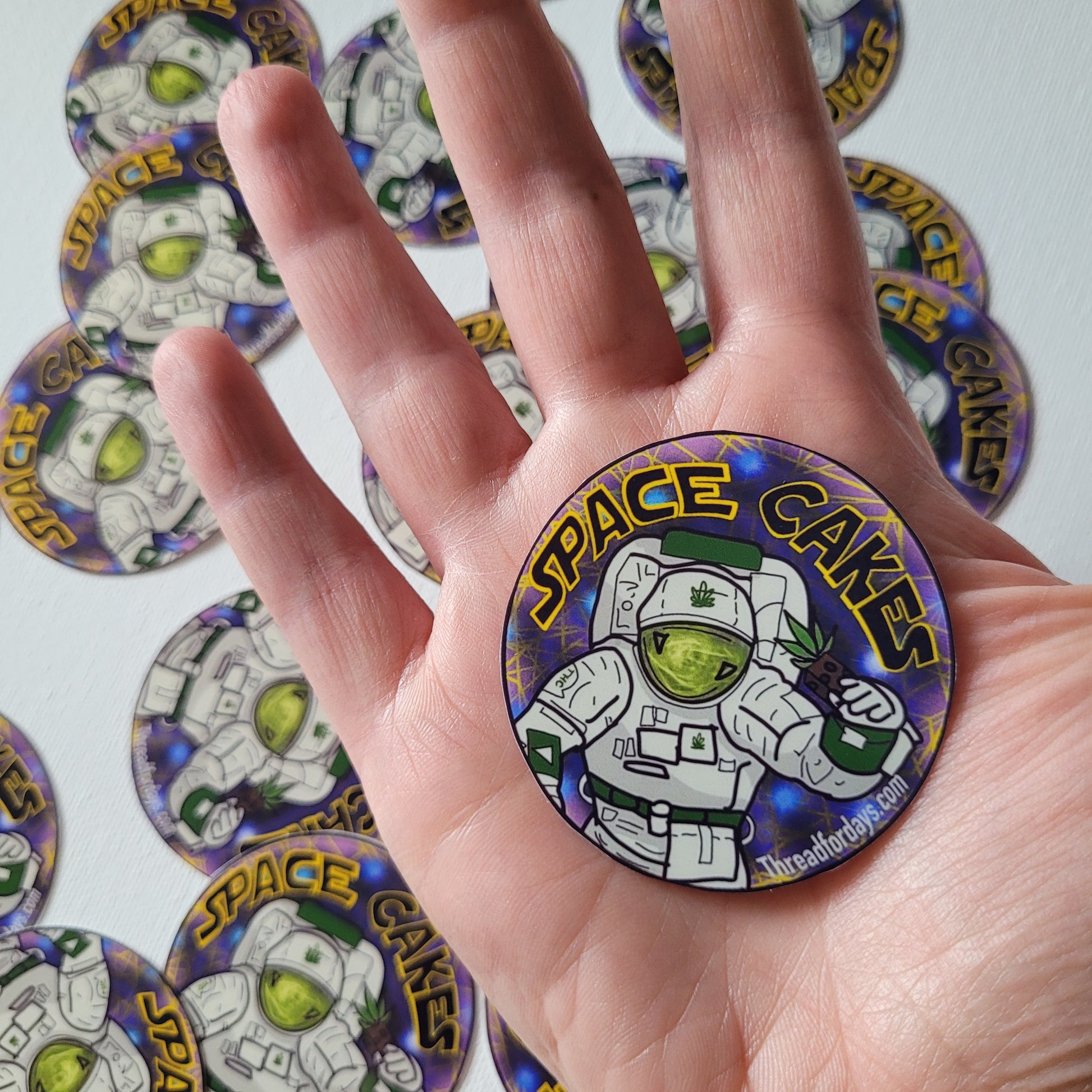 space cakes sticker held in palm to indicate size