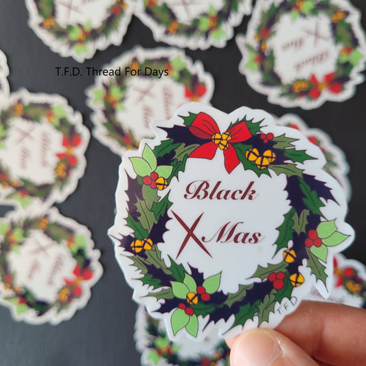 Black Xmas sticker close up held with fingers