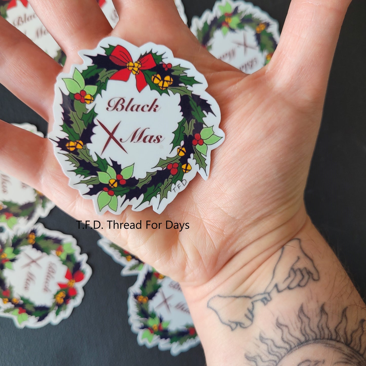 black xmas sticker held in palm of hand to demonstrate size