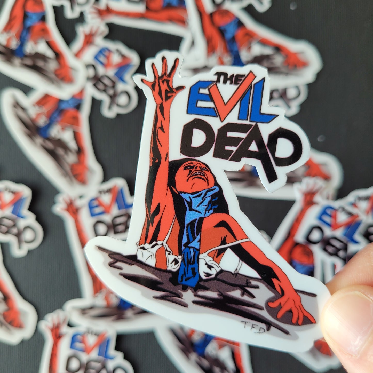the evil dead sticker held in fingers
