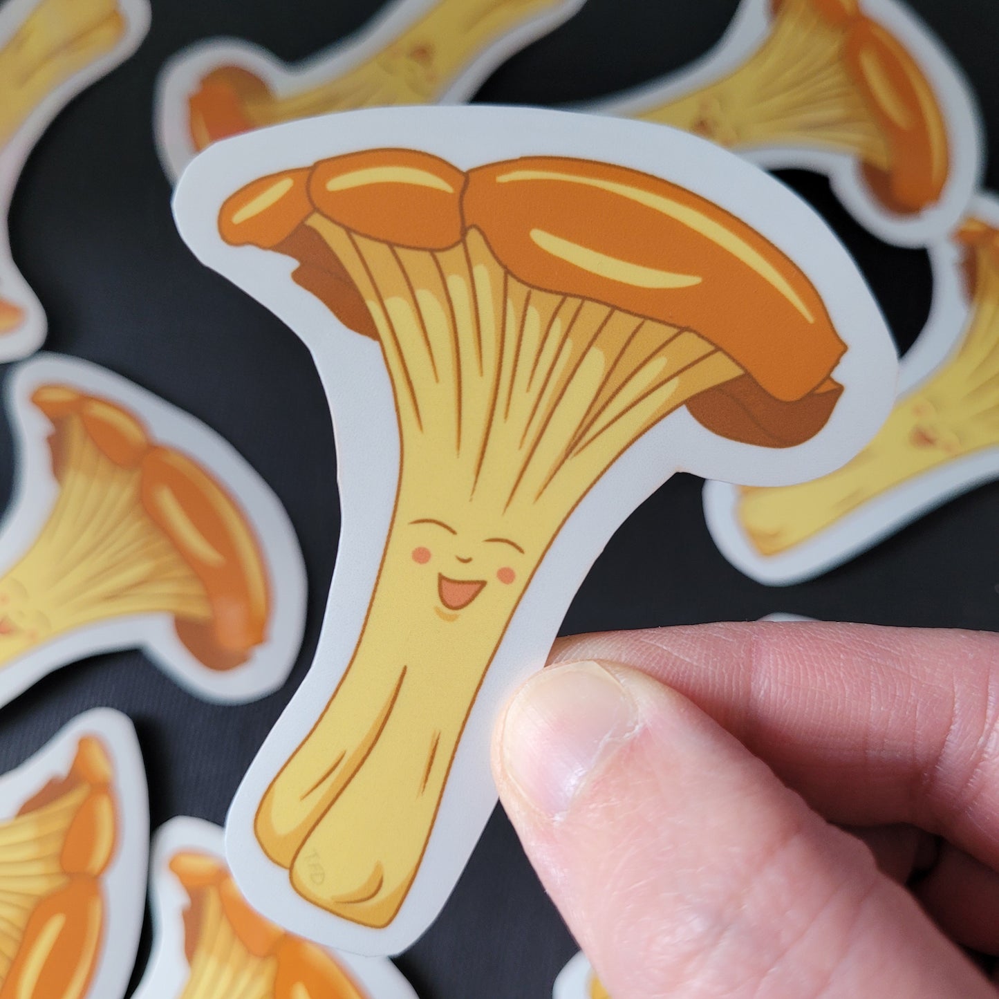 chanterelle mushroom sticker held between fingers