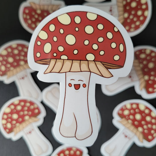 close up of anamita muscaria mushroom. The mushroom is red with white spots and is anthropomorphic with a smiling face and legs with 