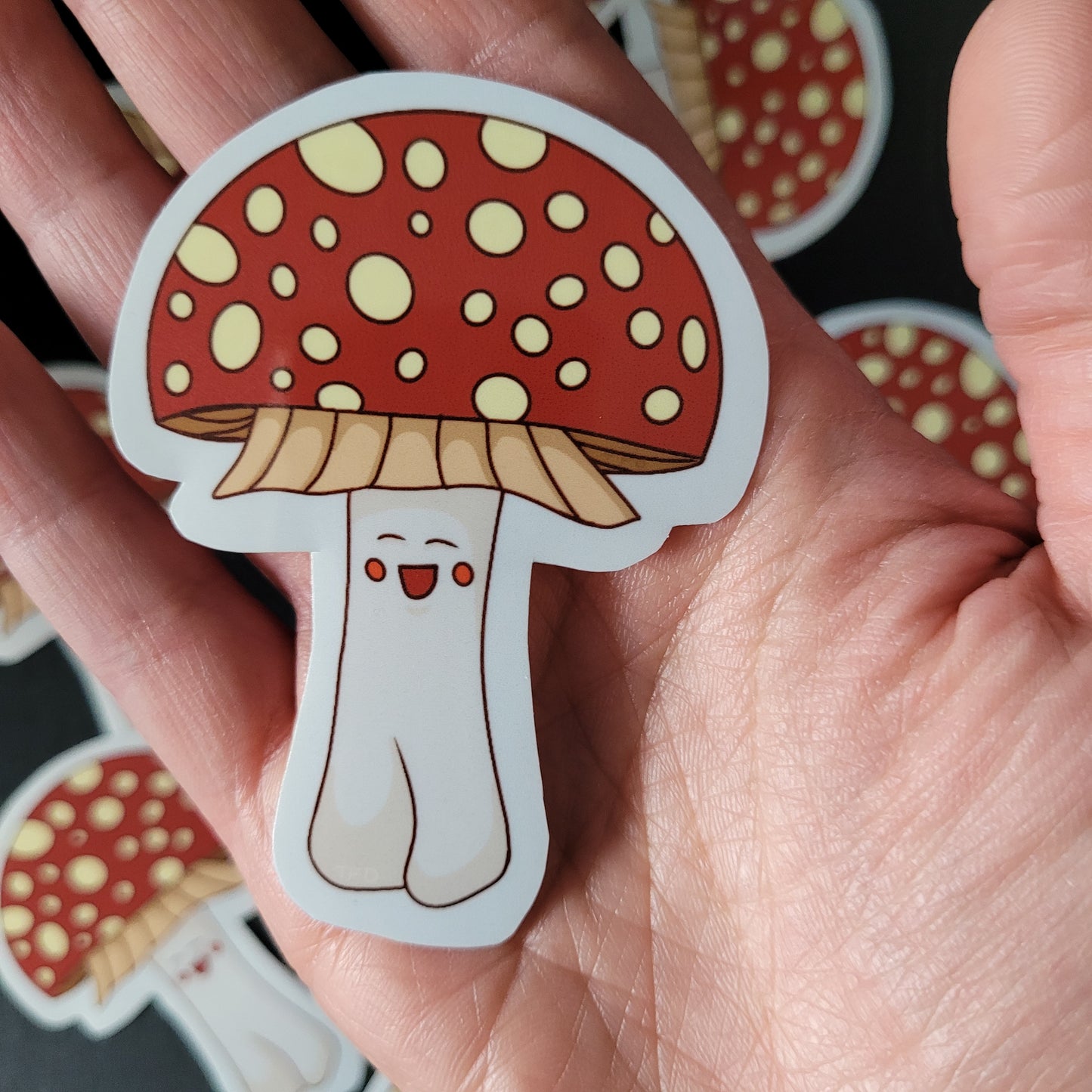 amanita muscaria sticker held in palm for size reference