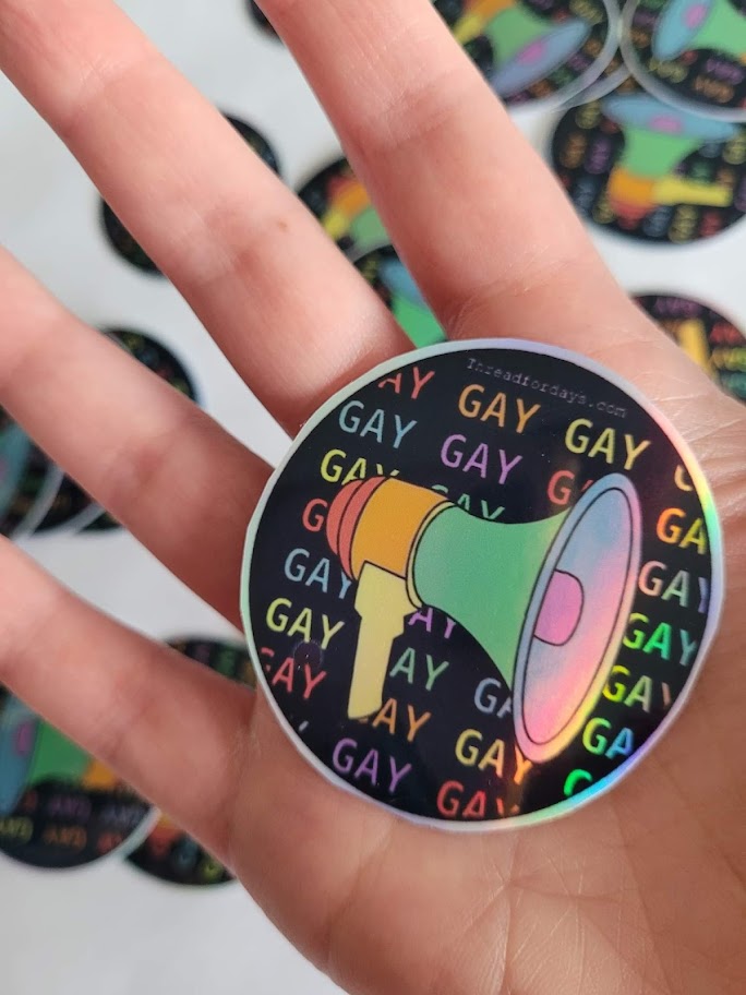 say gay sticker held in palm